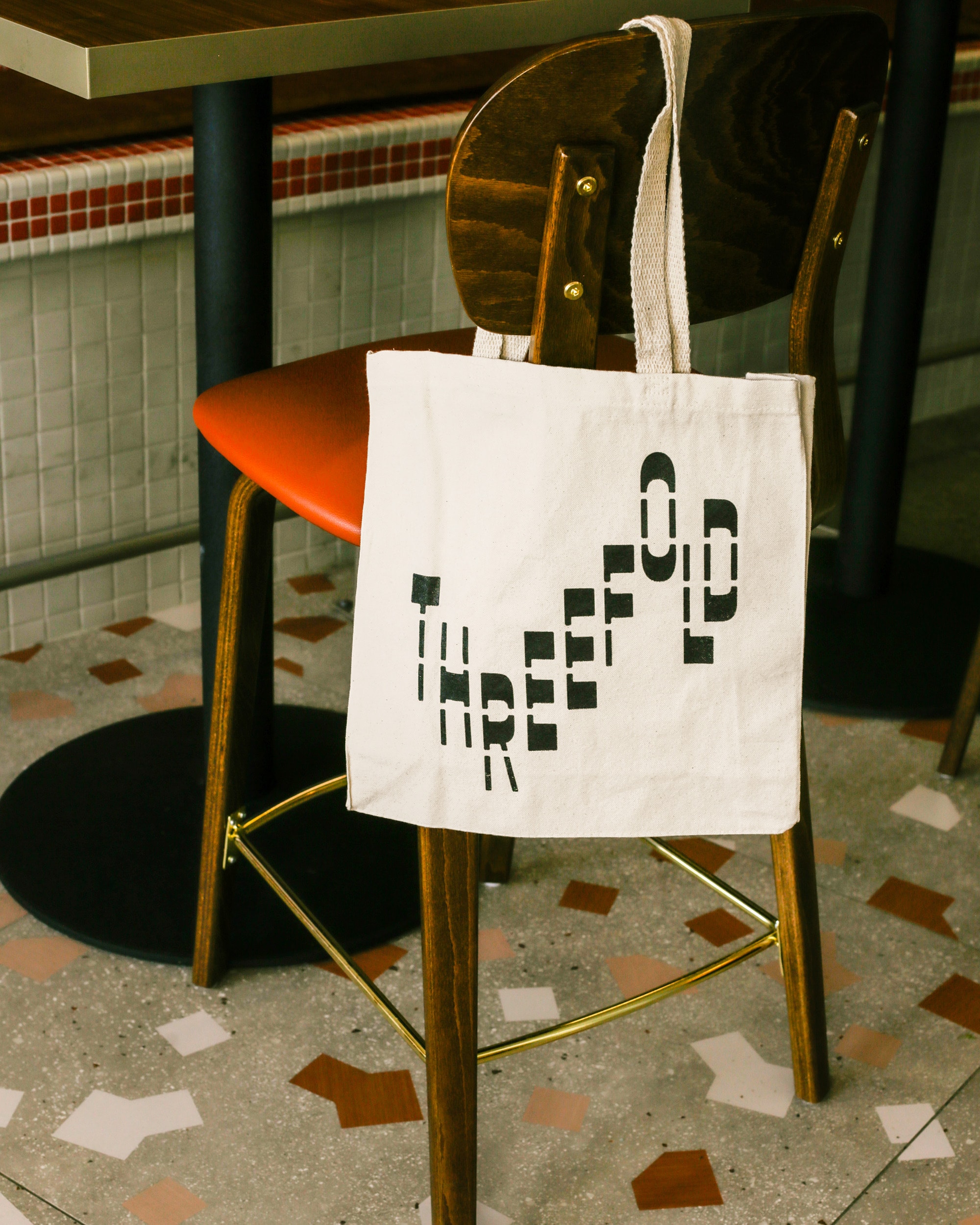 Threefold tote bag on a chair